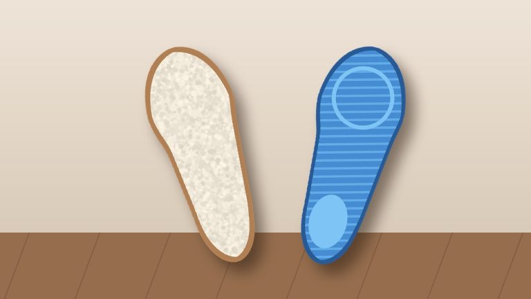 Zwei Einlegesohlen, eine aus Lammwolle und eine mit Gel, auf Holzboden